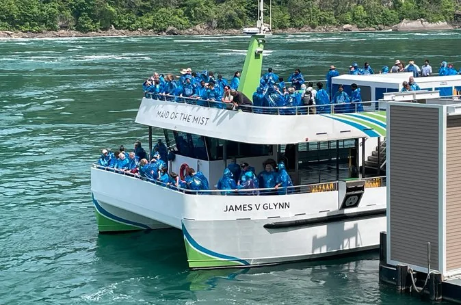 Das Maid-of-the-Mist-Boot James V. Glynn am Anleger mit Passagieren in blauen Ponchos
